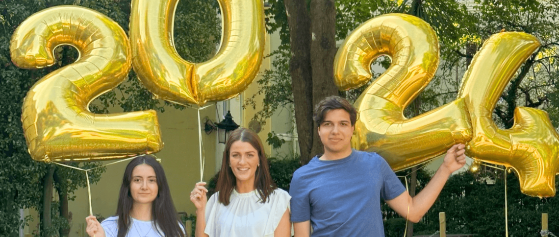 NBH A Level students stand smiling with results and balloons 2024